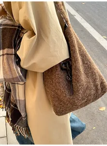 Outdoor shot of a brown plush shoulder bag showing textured faux fur and brand detail