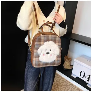 Detail view of brown plaid tote with cute plush puppy patch and adjustable leather straps