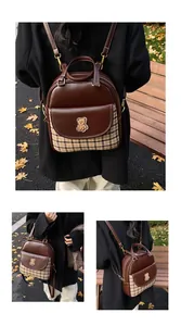 Detail of vintage brown leather backpack with plaid patterns and a cute bear patch