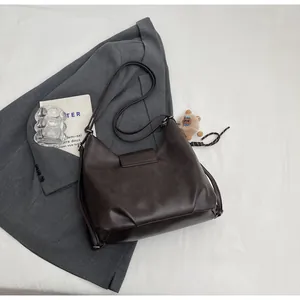 Dettaglio della borsa tote vintage in pelle PU marrone scuro con patta e hardware argento