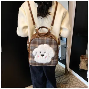 Detail of checkered tote bag featuring a cute plush dog patch and leather straps