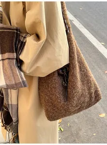 Brown fuzzy plush bucket bag with brand label styled with autumn coat and scarf