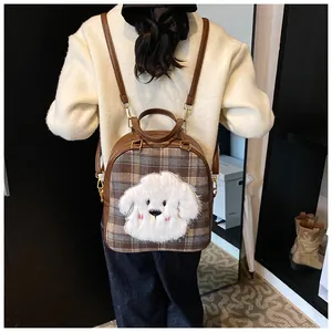 Detail of cute plush puppy head and plaid fabric on a large casual tote bag