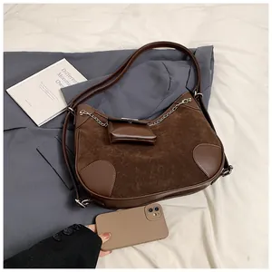 Detalle del bolso tote de ante marrón con cadena plateada y mini estuche desmontable