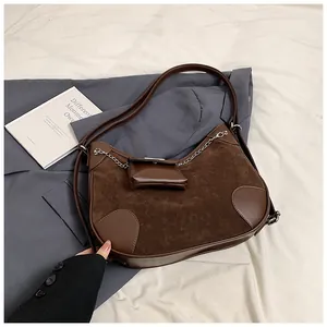 Detalle del bolso tote de ante marrón oscuro con cadena plateada y mini monedero extra