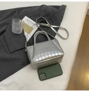 Nahaufnahme der silbernen Stepptasche im Größenvergleich mit einem Smartphone