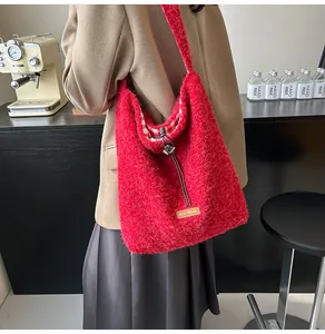 Detail of red plush faux fur bucket bag with drawstring closure and checked lining