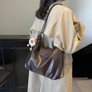 Borsa tote vintage marrone scuro mostrata di schiena sul modello con un trench coat beige