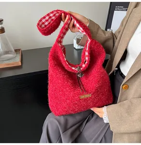 Detail of red plush shoulder bag featuring brand label and vintage plaid lining