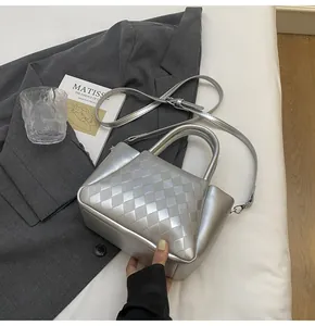 Detail der silbernen gesteppten Beuteltasche mit Webstruktur und Metallic-Finish