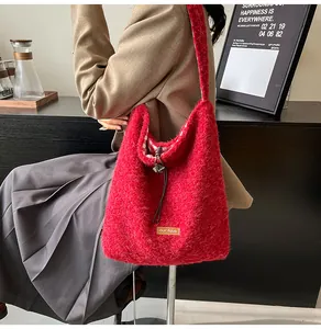 Detail of red plush bucket bag with drawstring closure and plaid lining detail