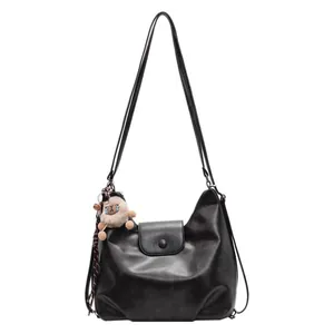 Grande borsa hobo vintage in pelle nera con tracolla e ciondolo di peluche