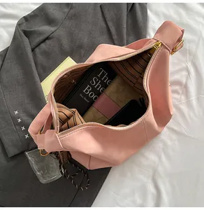 Pink suede hobo bag interior showing large capacity and elegant striped lining details