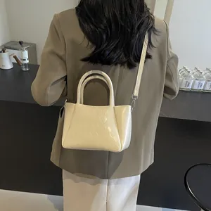 Beige gewebte Leder-Umhängetasche an einem Modell in einem minimalistischen modernen Design