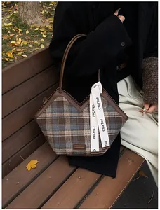 Close-up of plaid fabric tote bag featuring V-shape opening and decorative ribbon