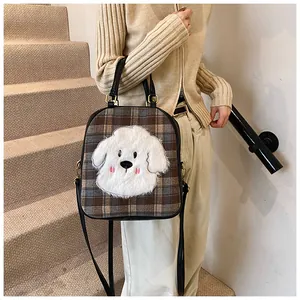 Close-up of vintage plaid tote bag featuring a 3D plush puppy patch and shoulder strap