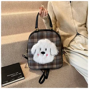 Detail of checkered tote bag with plush puppy design and premium golden hardware