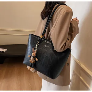 Détail du sac cabas vintage noir avec texture cuir et accessoire de charme lapin