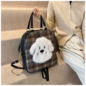 Close-up of brown plaid tote bag featuring a cute plush dog face and black leather straps
