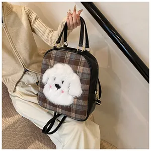 Close-up of leather tote bag featuring a plush cartoon dog patch and golden hardware