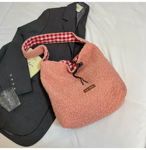 Detail of pink plush bucket bag featuring red checkered lining and drawstring closure