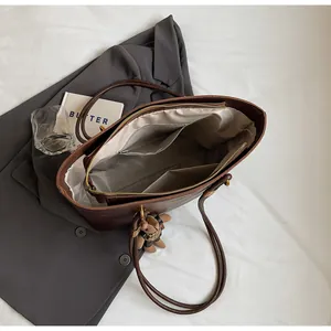 Vue intérieure du grand cabas en cuir marron avec poche zippée et texture souple