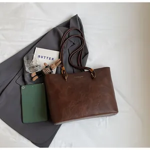 Détails du cabas vintage en cuir marron avec texte doré et breloque lapin mignonne