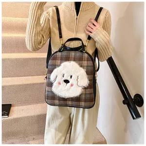Detail of checkered tote bag with large plush puppy patch and black leather strap