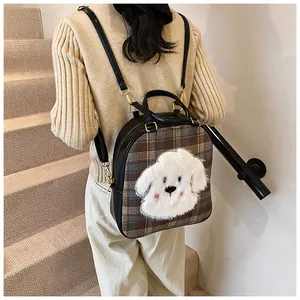 Detail of checkered tote bag with plush puppy decor and premium leather strap