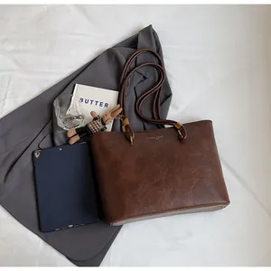 Détail d'un grand sac cabas marron foncé avec texture vintage et finitions dorées chic