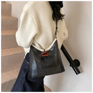 Detail view of the brown leather tote bag featuring white faux fur trim and toggle buttons