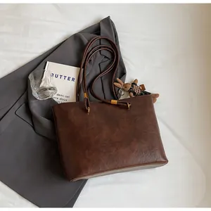 Détail du sac cabas marron vintage avec texture cuir et breloque lapin mignonne