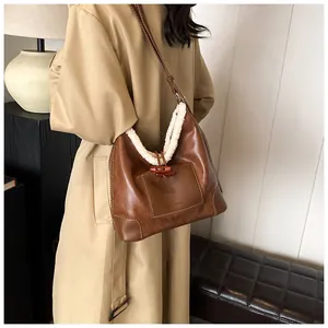 Detail of vintage caramel leather tote bag with white fleece trim and horn button accent