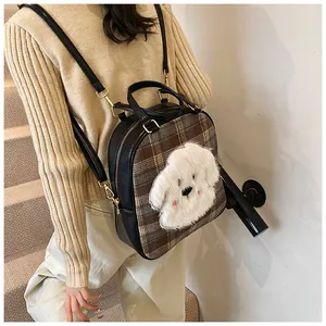 Detail showing checkered tote bag with cute 3D cartoon dog patch and brown plaid pattern
