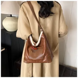 Close-up of retro brown hobo bag with white faux fur trim and wooden horn buckle detail
