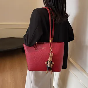 Sac fourre-tout vintage rouge foncé en cuir souple avec un joli pendentif de lapin