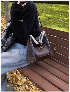 Detailed view of the dark brown faux leather bag with white faux fur trim and toggle buttons