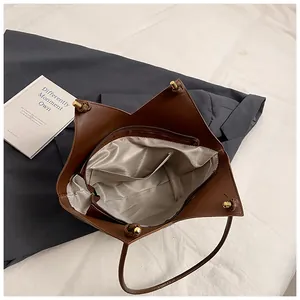 Top view of brown tote bag showing spacious interior with striped lining and pockets