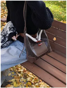 Detail view of brown retro shoulder bag with faux fur trim and wooden toggle buttons