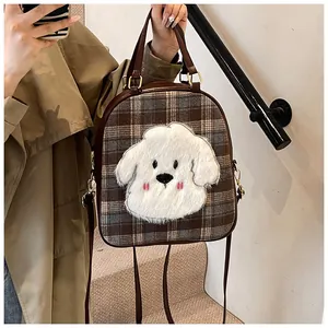 Detail of checkered tote bag with plush puppy patch and adjustable leather strap