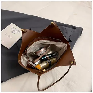 Top view of brown tote bag interior showing spacious compartments and golden hardware