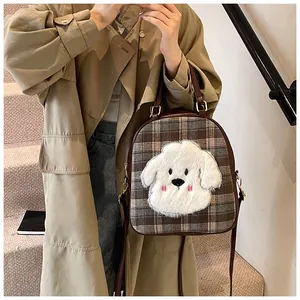 Detail of checkered tote bag featuring a plush cartoon dog and brown leather trim
