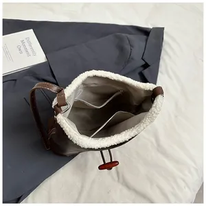 Detailed view of the internal storage pocket and faux fur trim on this brown tote bag