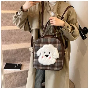 Detailed view of plaid tote bag featuring a cute 3D plush puppy and gold hardware
