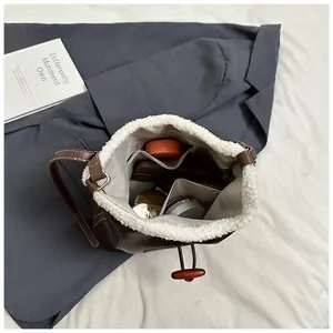 Detail showing interior storage of brown bucket bag with plush white trim and leather strap