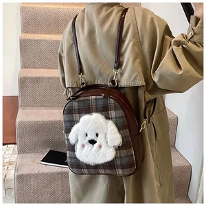 Detailed view of the plaid backpack with plush puppy patch on a model in trench coat