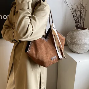 Brown suede tote bag with V-cut design and stylish logo strap for autumn fashion