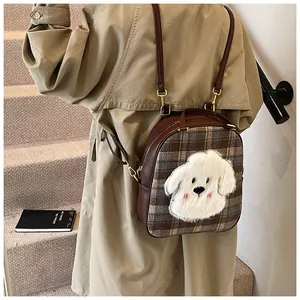 Close-up of the vintage plaid tote bag with plush dog applique and leather strap detail