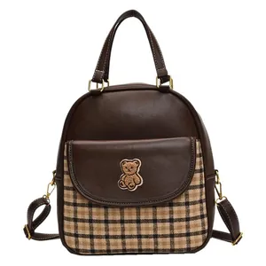 Deep brown leather backpack with plaid fabric detail and cute bear embroidery patch