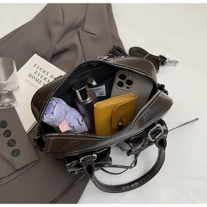 Deep brown high-gloss underarm bag showing spacious interior with everyday essentials